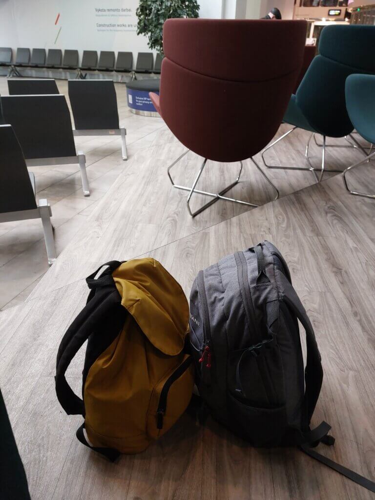 Two small daybags sitting on the floor at the Vilnius airport