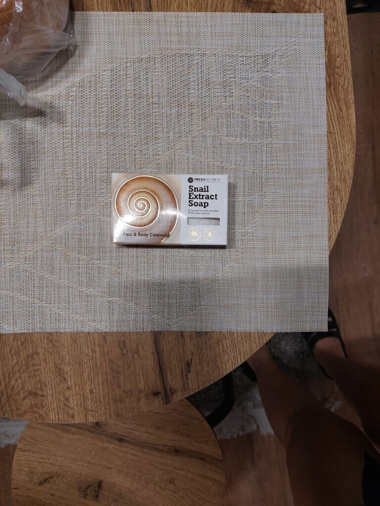 Snail extract soap for cleaning face laid out on a table