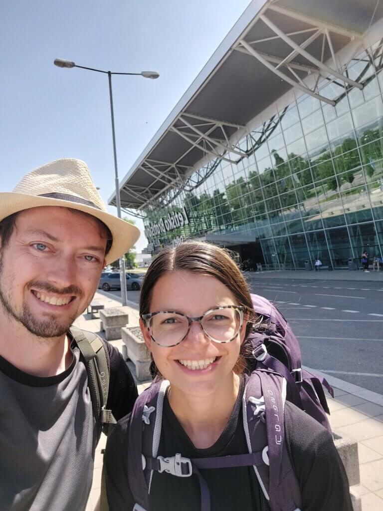 Mirka and Daniel taking a selfie outside of the Bratislava airport with big Osprey backpacks on