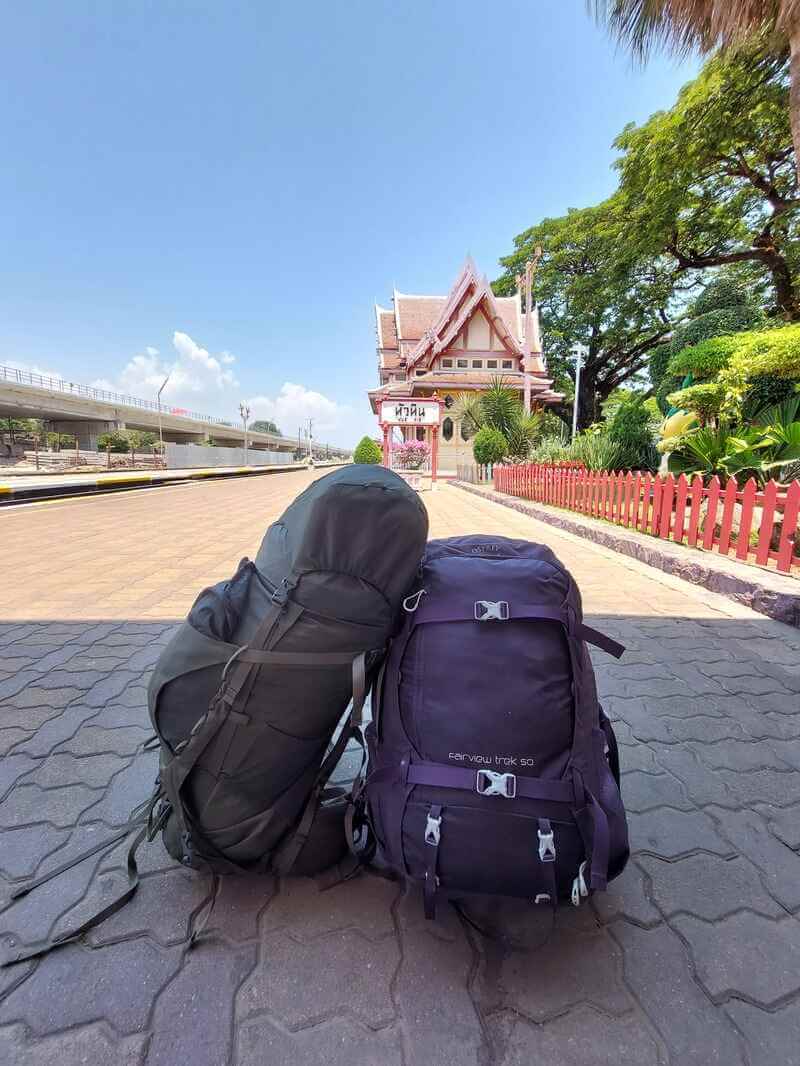 Two big Osprey backpacks on the ground of a train station