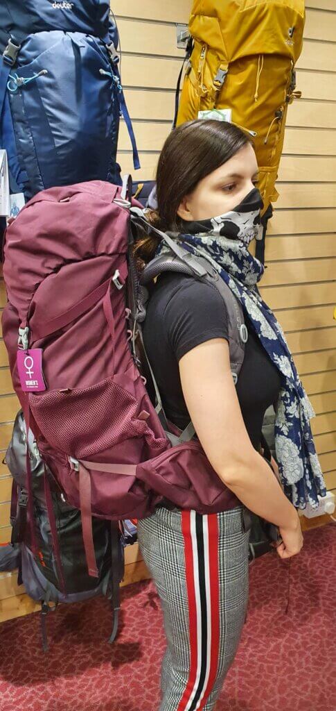 Mirka trying on a big backpack in a shop