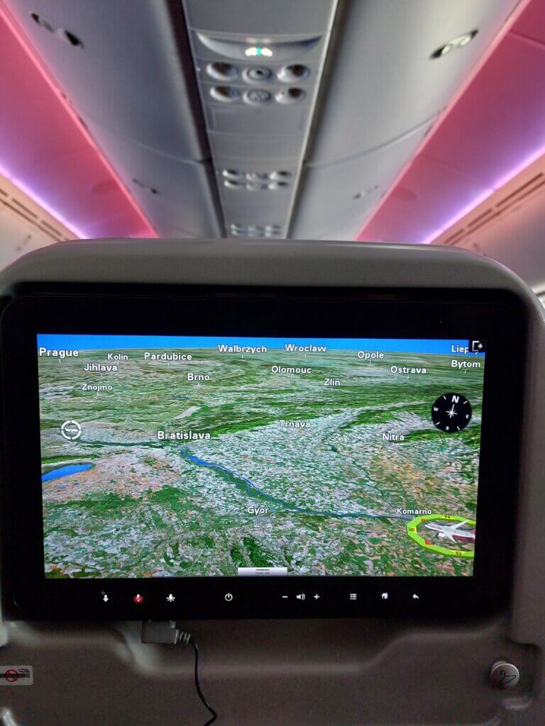A screen on a plane showing a map of Slovakia and a plane approaching an airport.