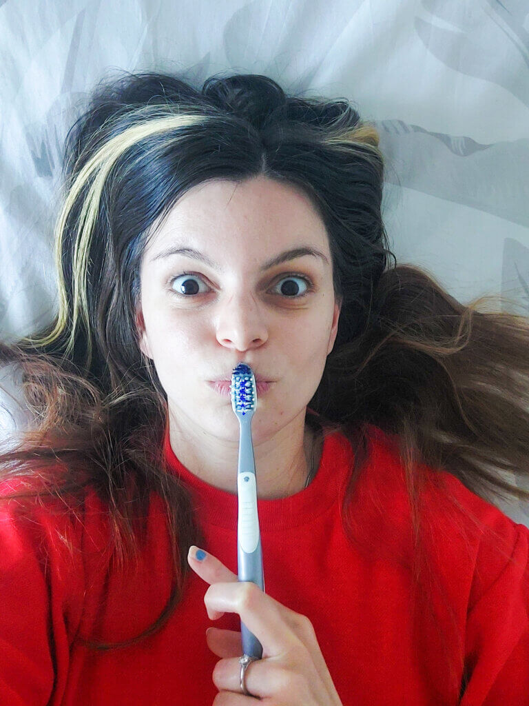 Mirka holding a toothbrush to her lips