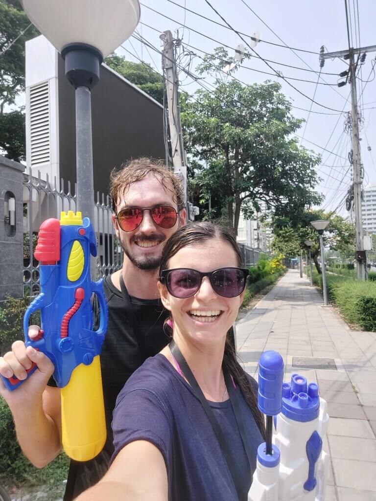 Mirka and Daniel taking a selfie on a street holding up water guns