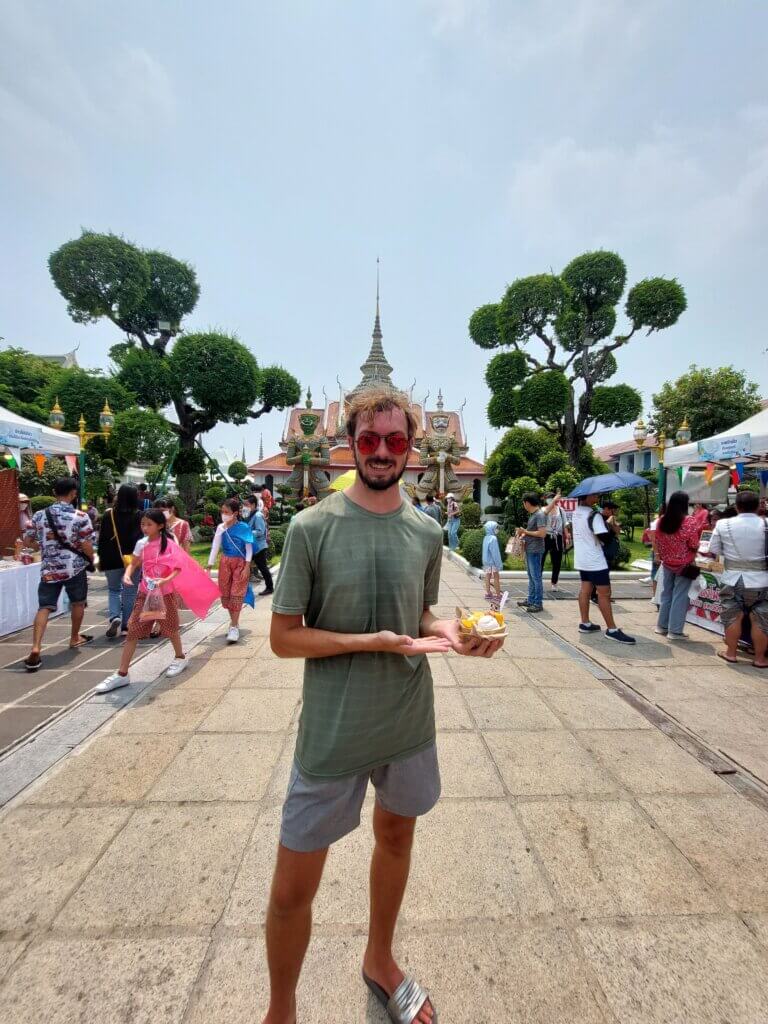 Daniel holding a bowl of ice cream wearing a thin T-shirt and shorts