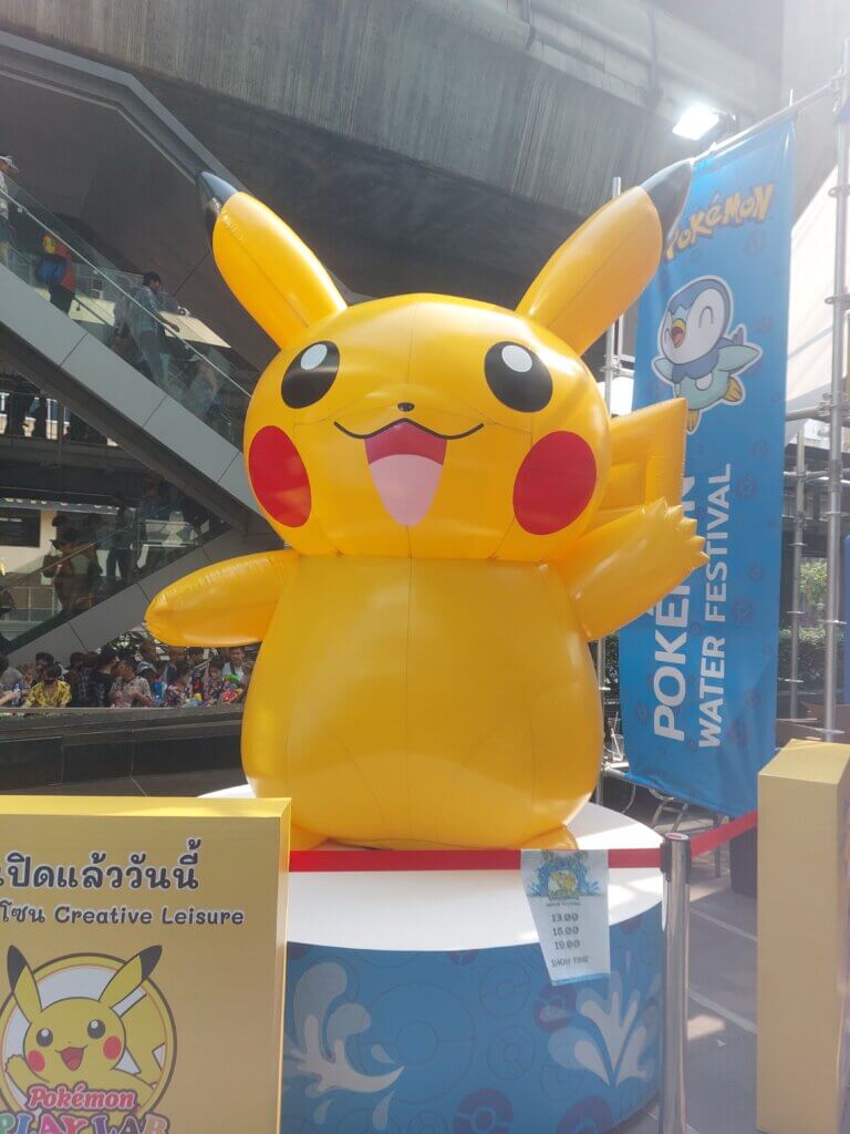 A big inflatable Pikachu with Songkran ravers behind it