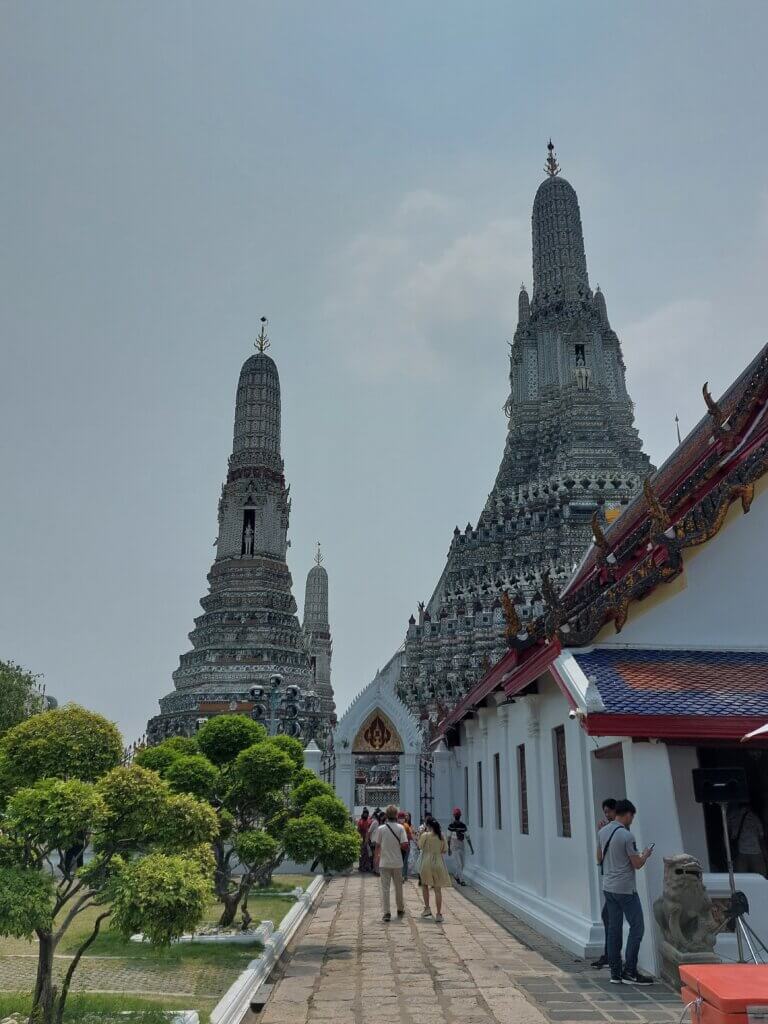Wat Arun temple with visitors walking around the temple grounds