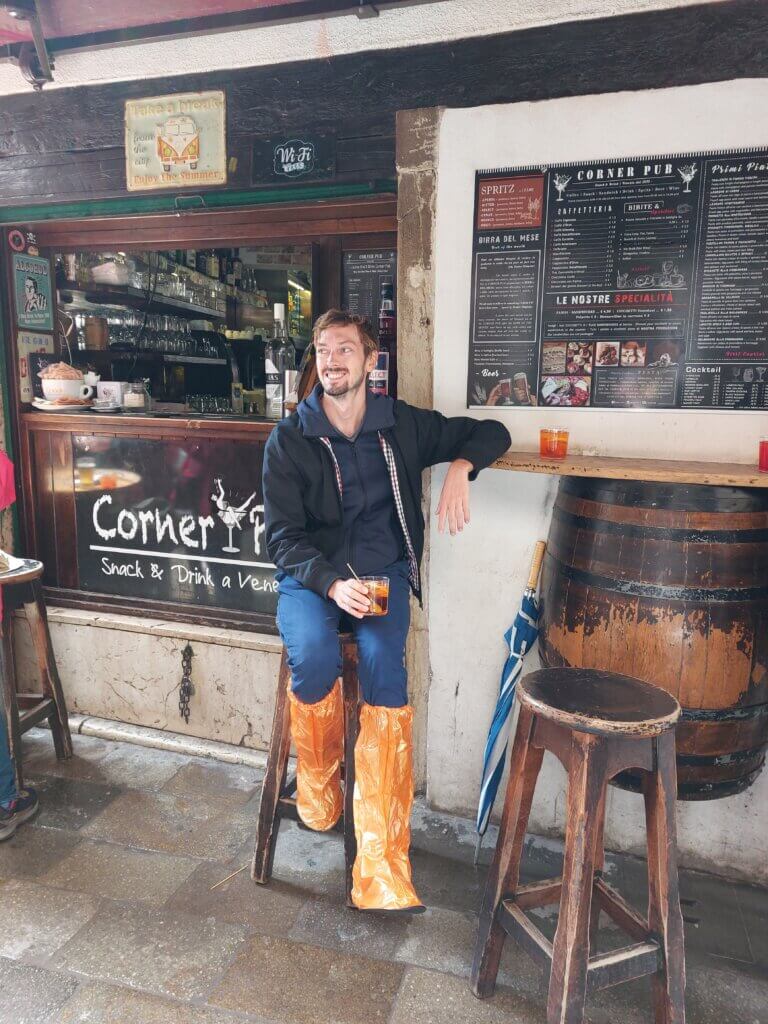 Daniel sitting outside a small bar in Venic with an Aperol Spritz