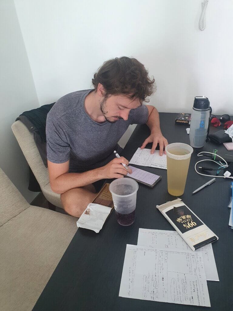 Daniel working at a table with papers and 99% Lindt chocolate on it