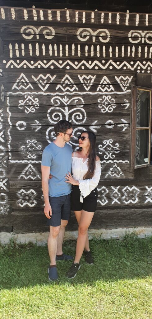 Mirka and Daniel posing in front of a folklore-painted house in Cicmany