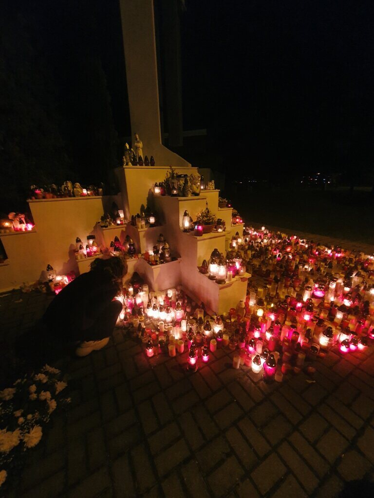 A big cross monument with hundreds of candles lit up