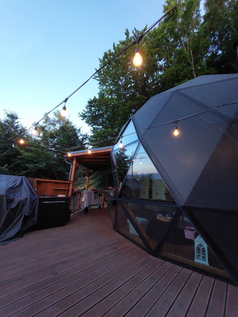 Dome and a wooden terrace with fairy lights strung up above