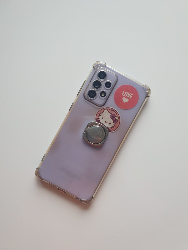 A purple mobile phone lying face-down on a table