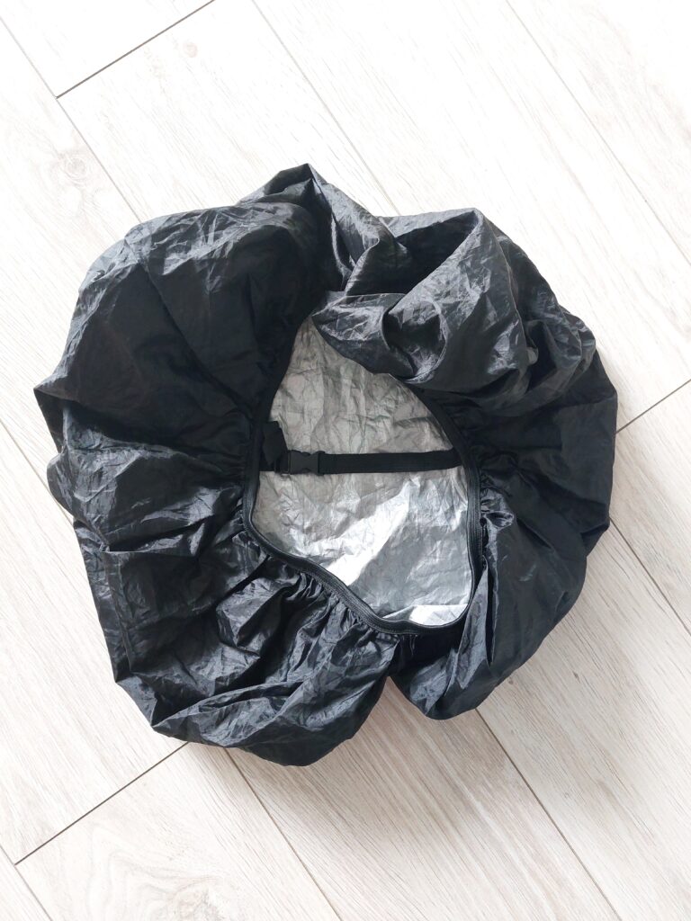 Black rain cover with a strap going across the back