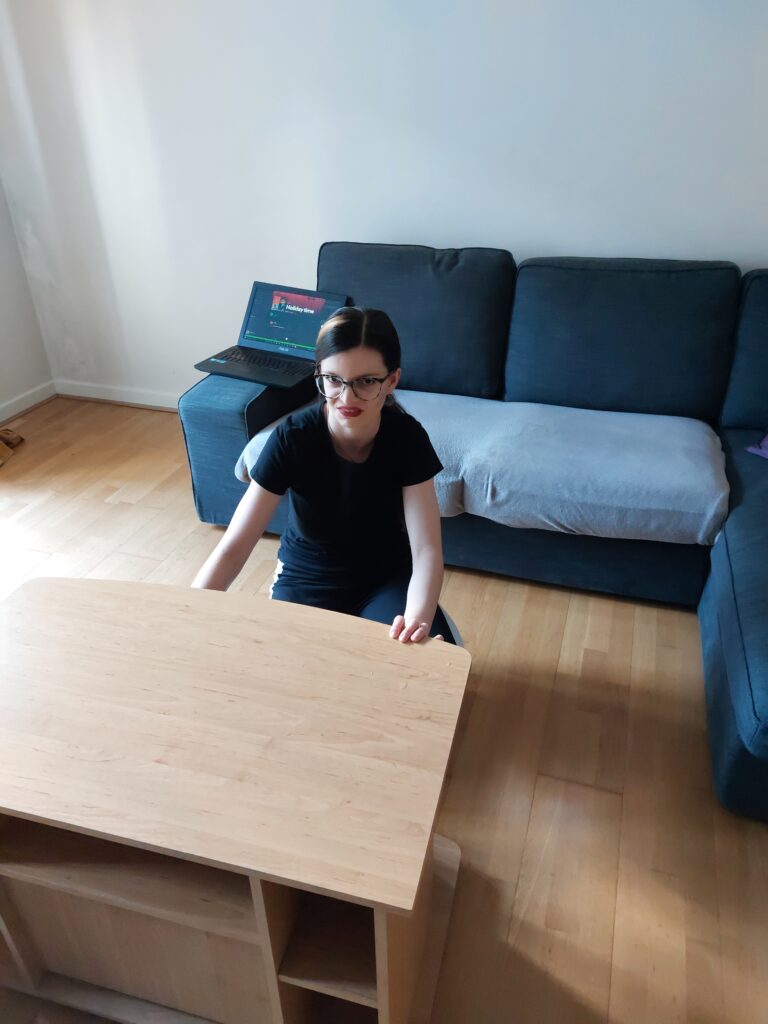 Mirka, making a face crouched at a coffee table while cleaning it