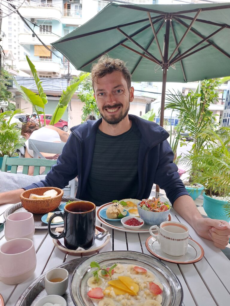 Daniel smiling across a table with Western-style breakfast.