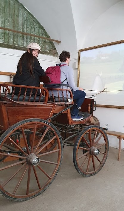 Mirka and Daniel sitting on an old carriage with a big projection screen in front of them