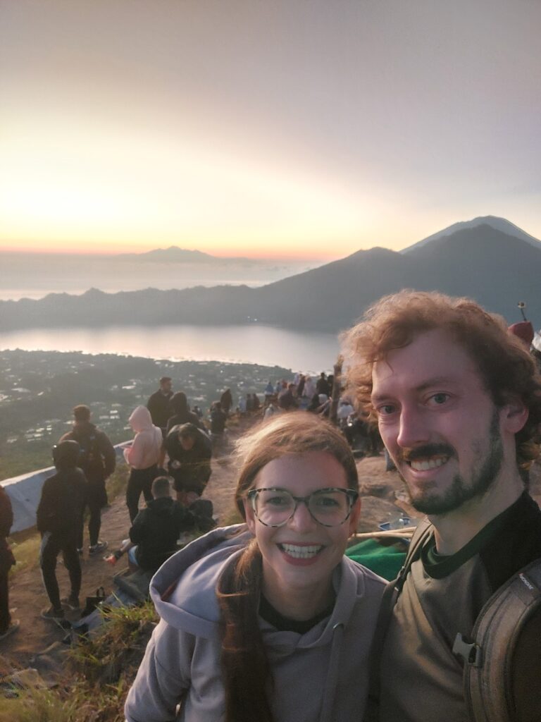Mirka and Daniel taking a selfie with sunrise on top of a volcano
