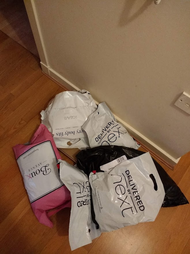 Packages from different clothes shops piled up on the floor