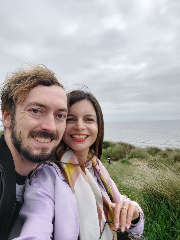Mirka and Daniel taking a selfie at a beach in Scotland