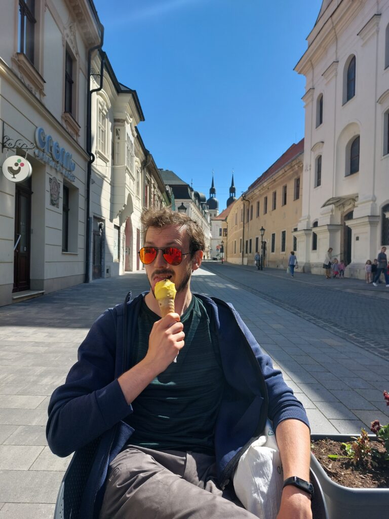 Daniel eating ice cream out on a street