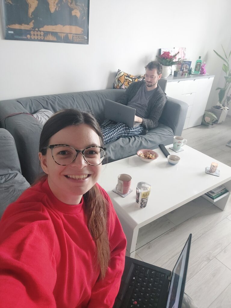 Mirka and Daniel sitting in a living room working on laptops