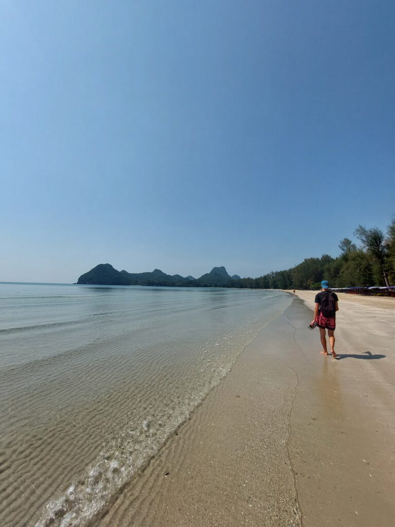 Daniel walking along an empty beach