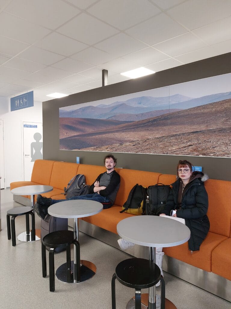 Daniel sitting next to bathrooms at an airport