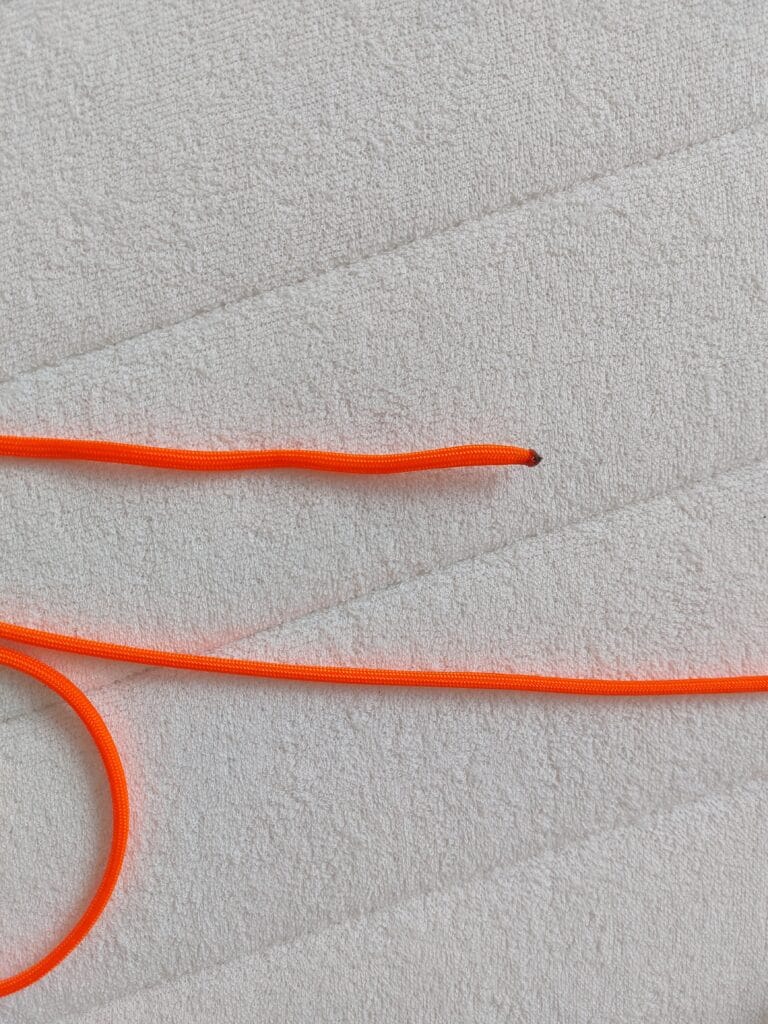 Burnt end of an orange paracord