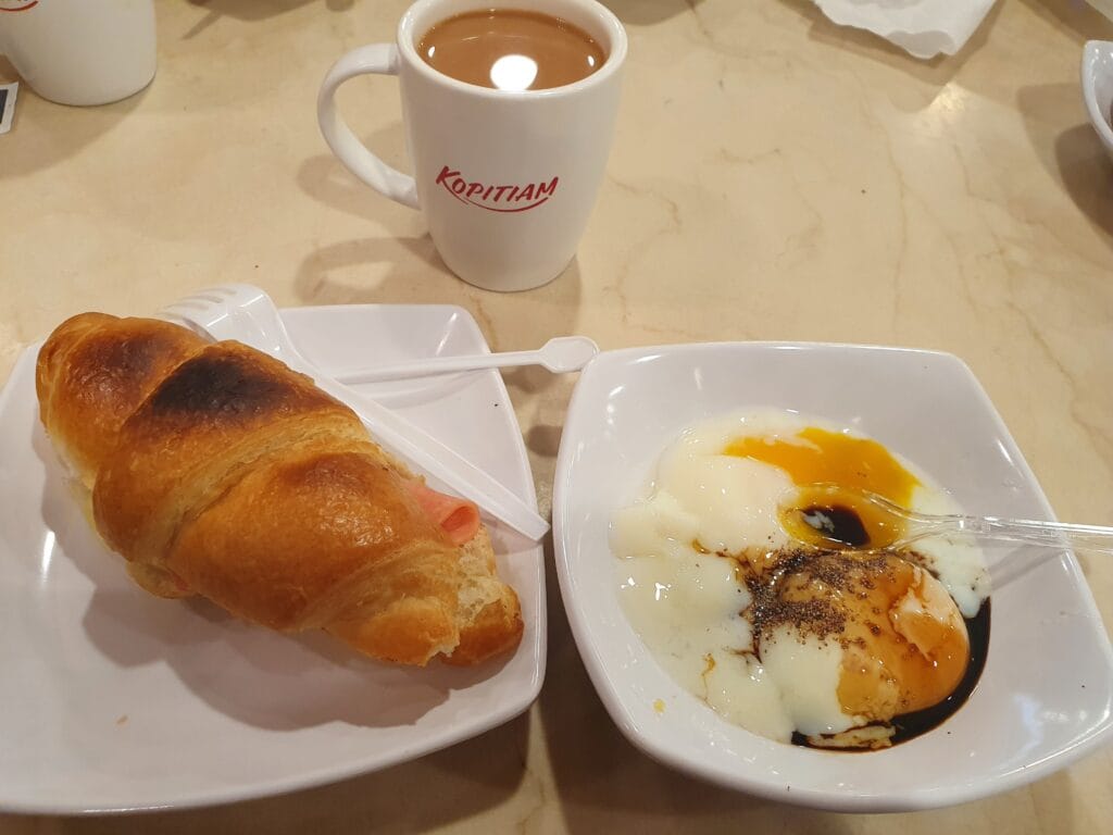 A ham croissant and a bowl of eggs