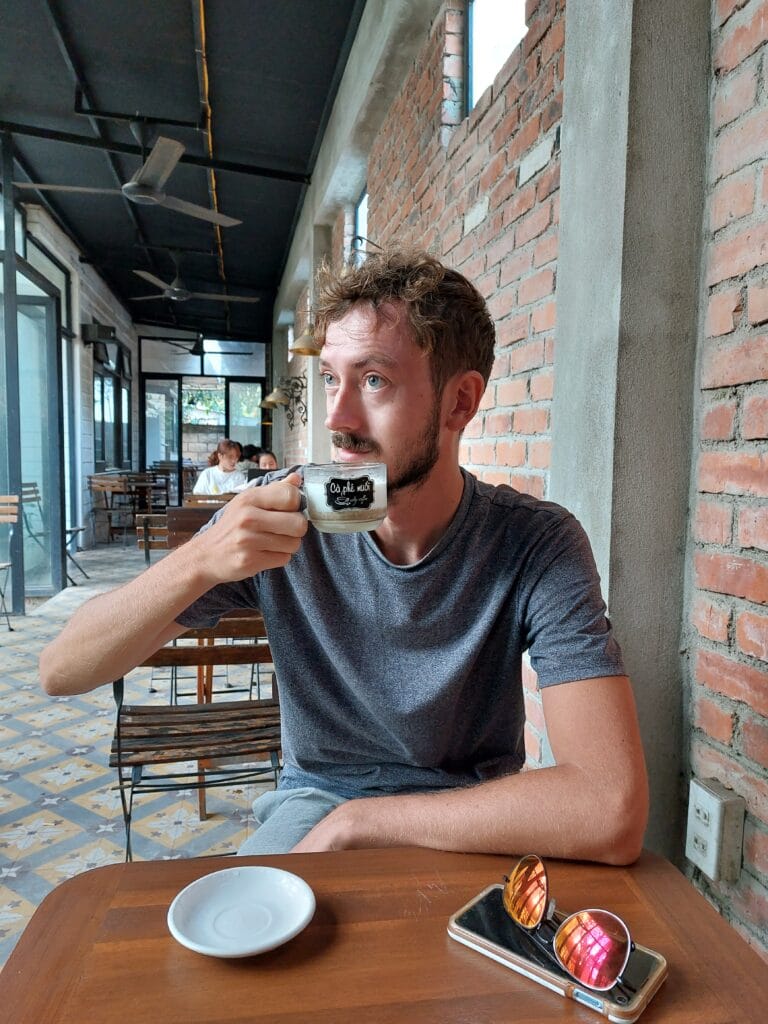 Daniel drinking coffee in a cafe