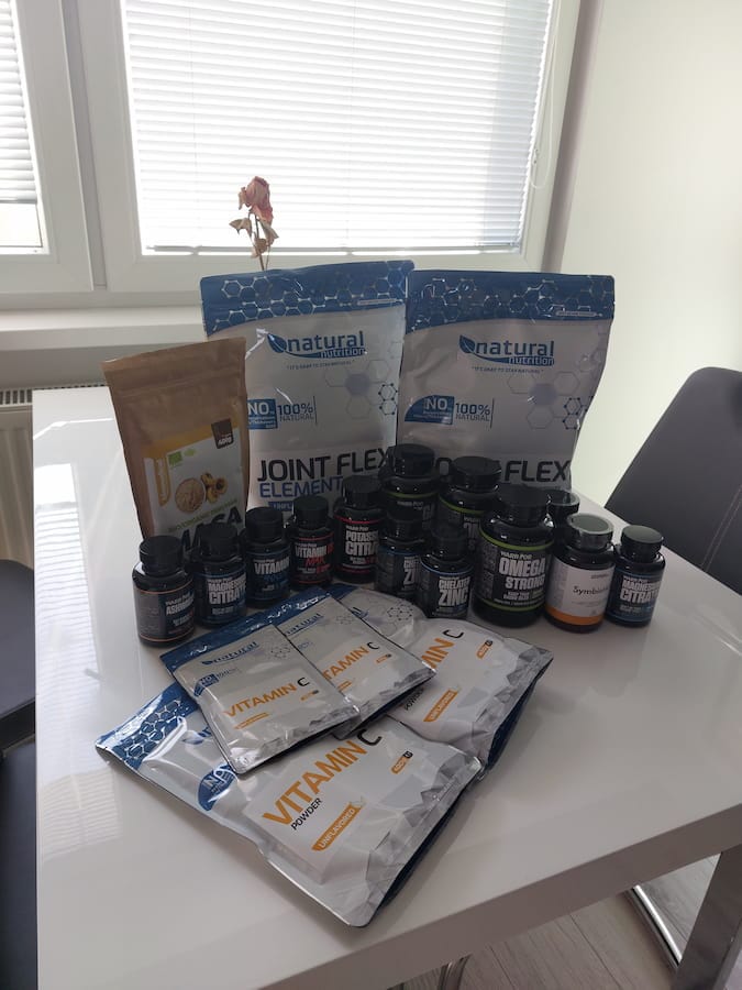 Packets and tubs of vitamins and supplements arranged on a table 