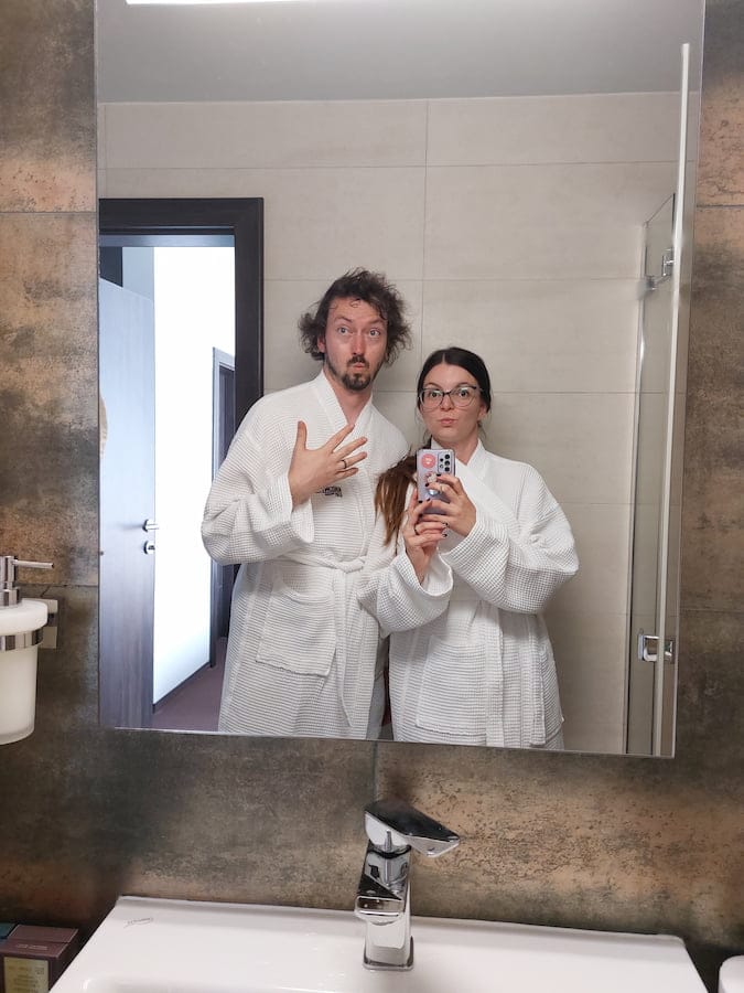 Mirka and Daniel wearing dressing gowns taking a bathroom selfie
