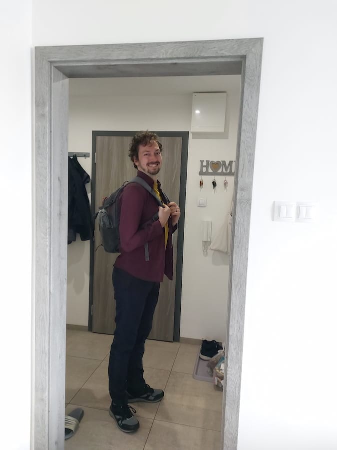 Daniel standing at the front door with a small backpack on