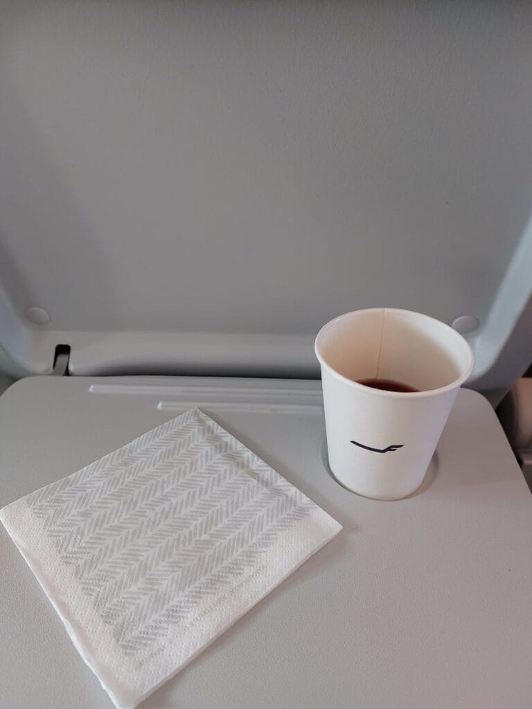 A berry juice in a paper cup on a plane