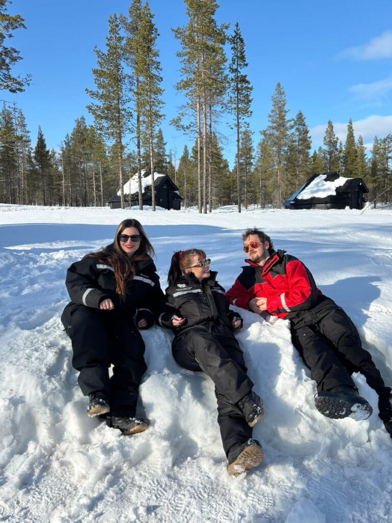 Mirka, Daniel and Mirka's sister lying in the snow in snowsuits