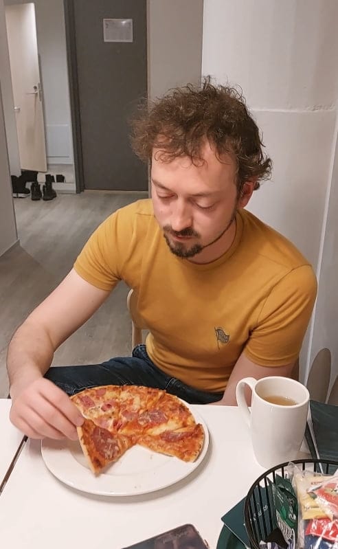 Daniel eating a frozen pizza