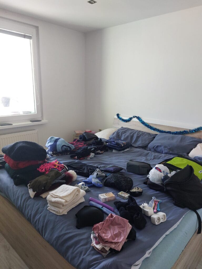 Clothes and travel accessories on a bed