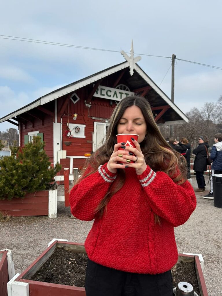 Mirka drinking a hot drink in front of Cafe Regatta
