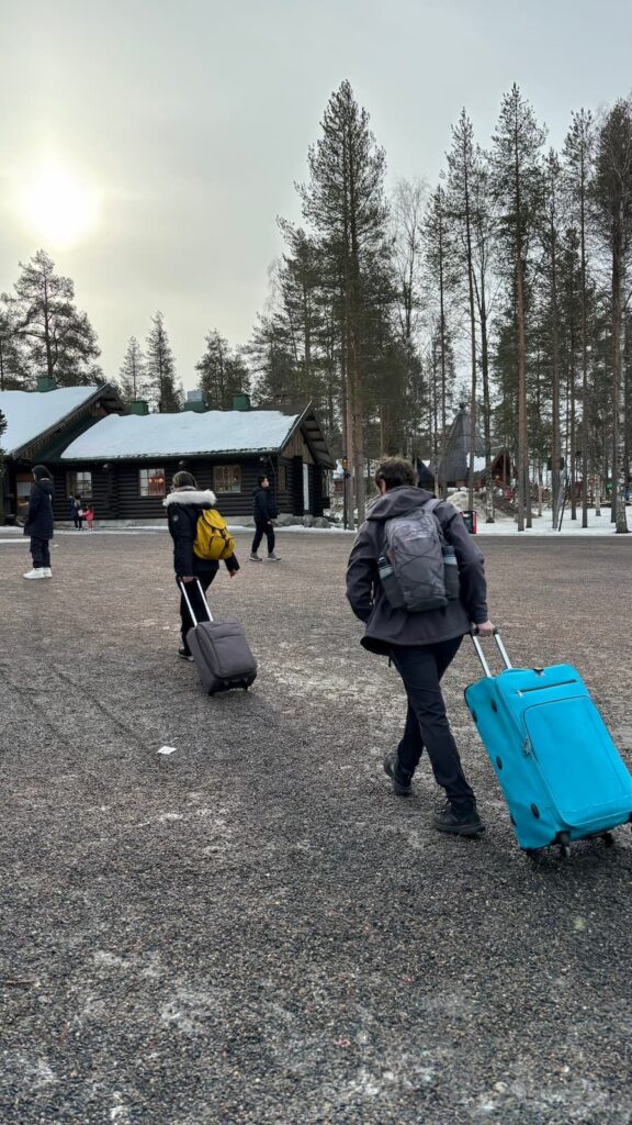 Mirka and Daniel pulling suitcases across gravel