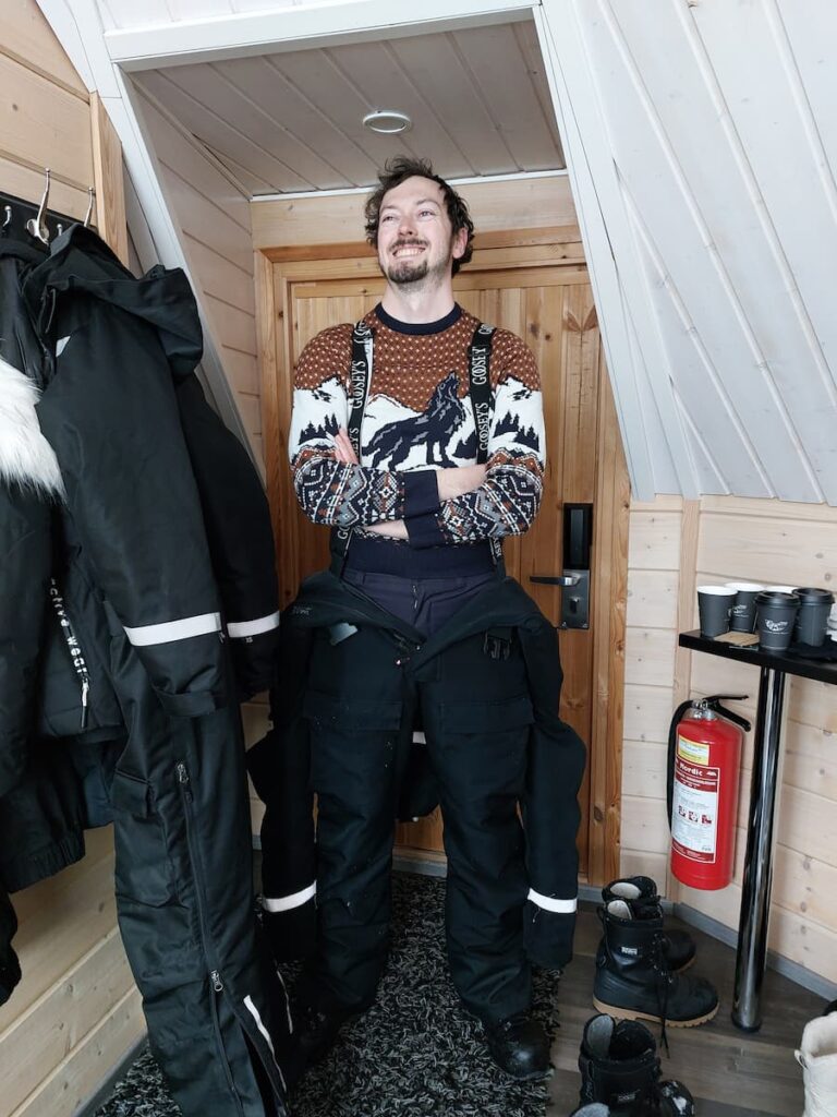 Daniel laughing while putting on a snowsuit
