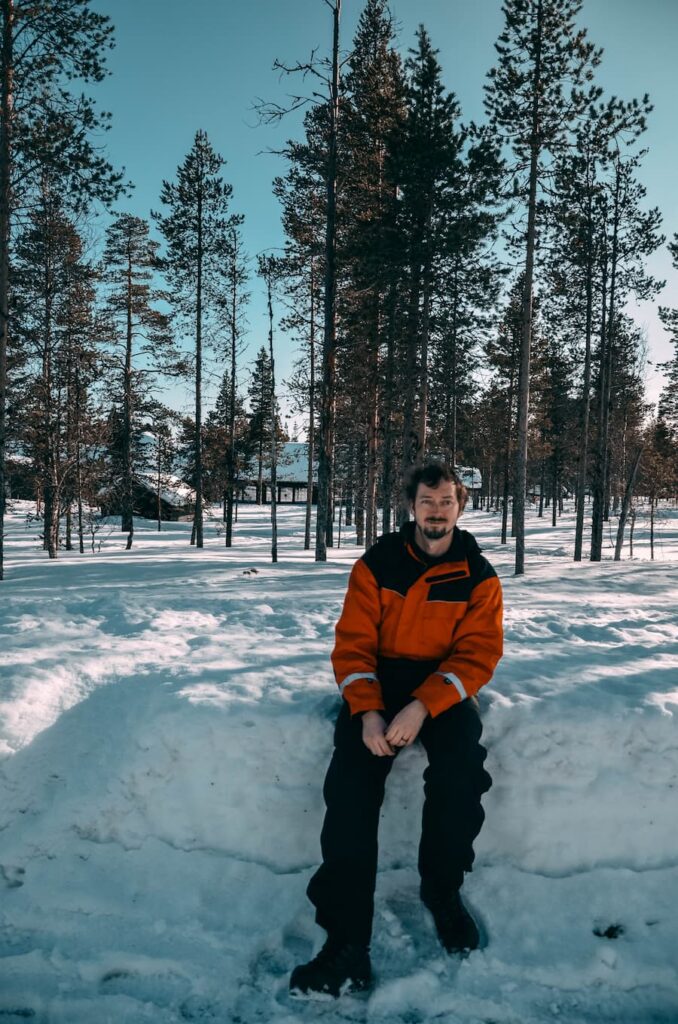 Daniel sitting on a snowbank