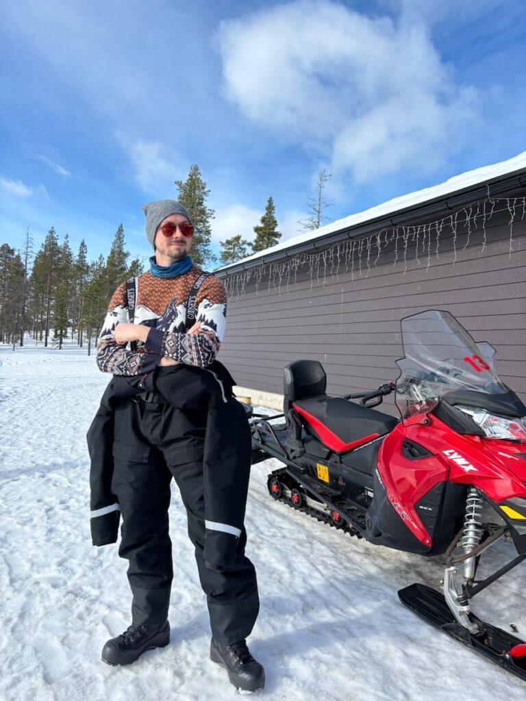 Daniel standing next to a snowmobile