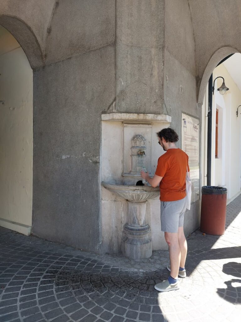 5 Best Cities to Visit from Bratislava—Easy Guide 10 Daniel topping up a water bottle from a mineral spring