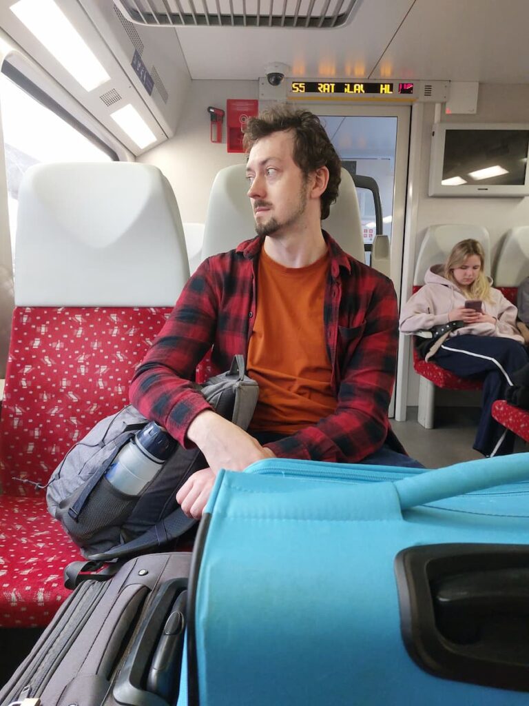 Daniel holding on to a backpack on a train