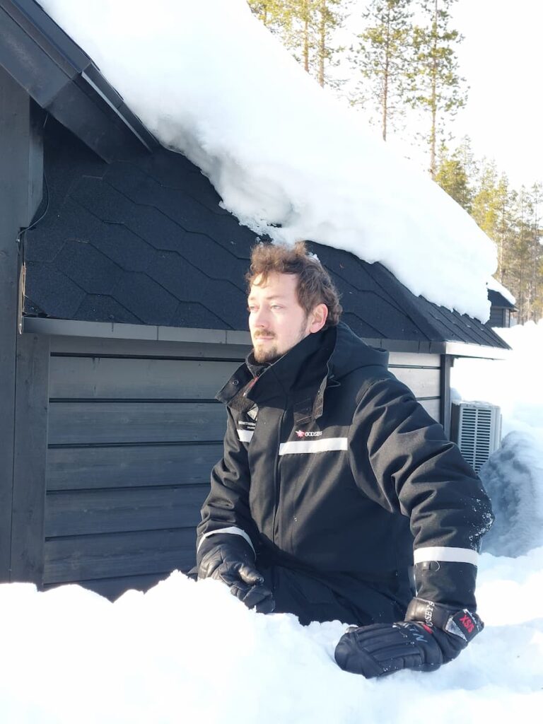 Daniel sitting in the snow with waterproof mittens