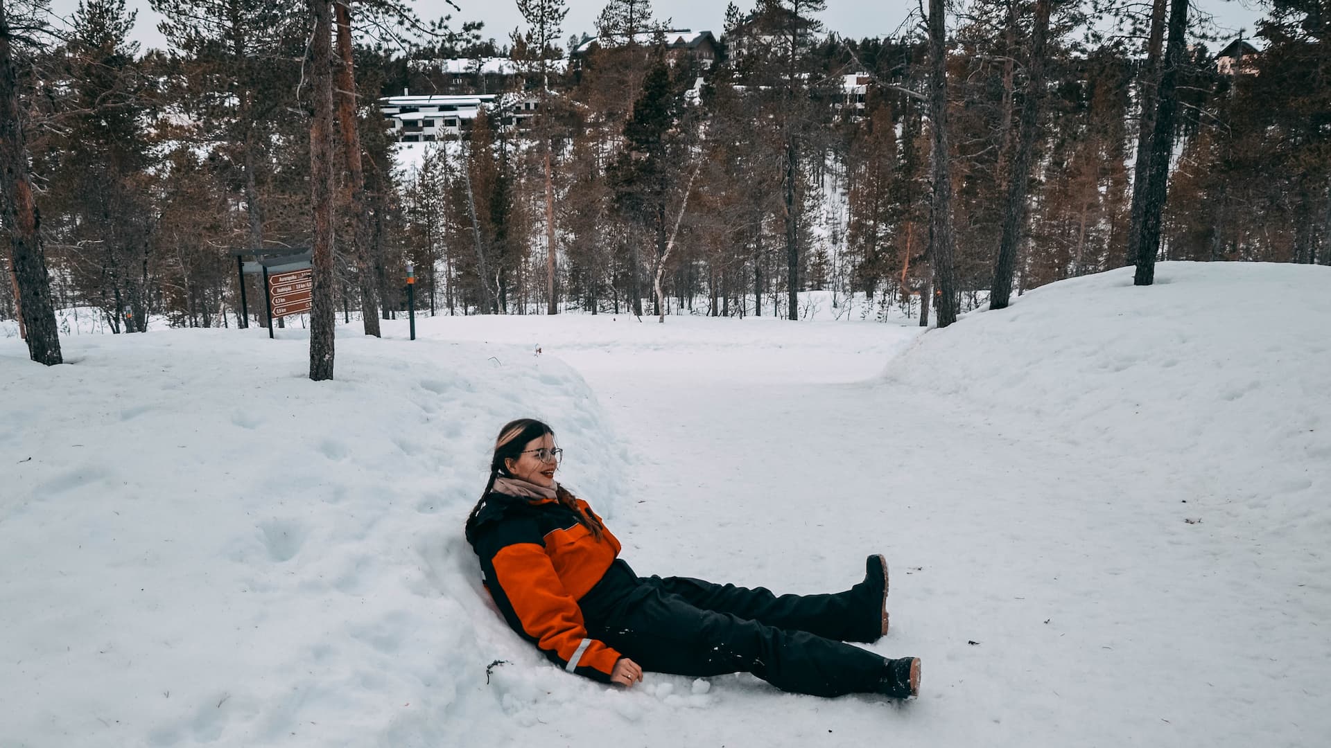 Mirka sitting on a snow path in Lapland