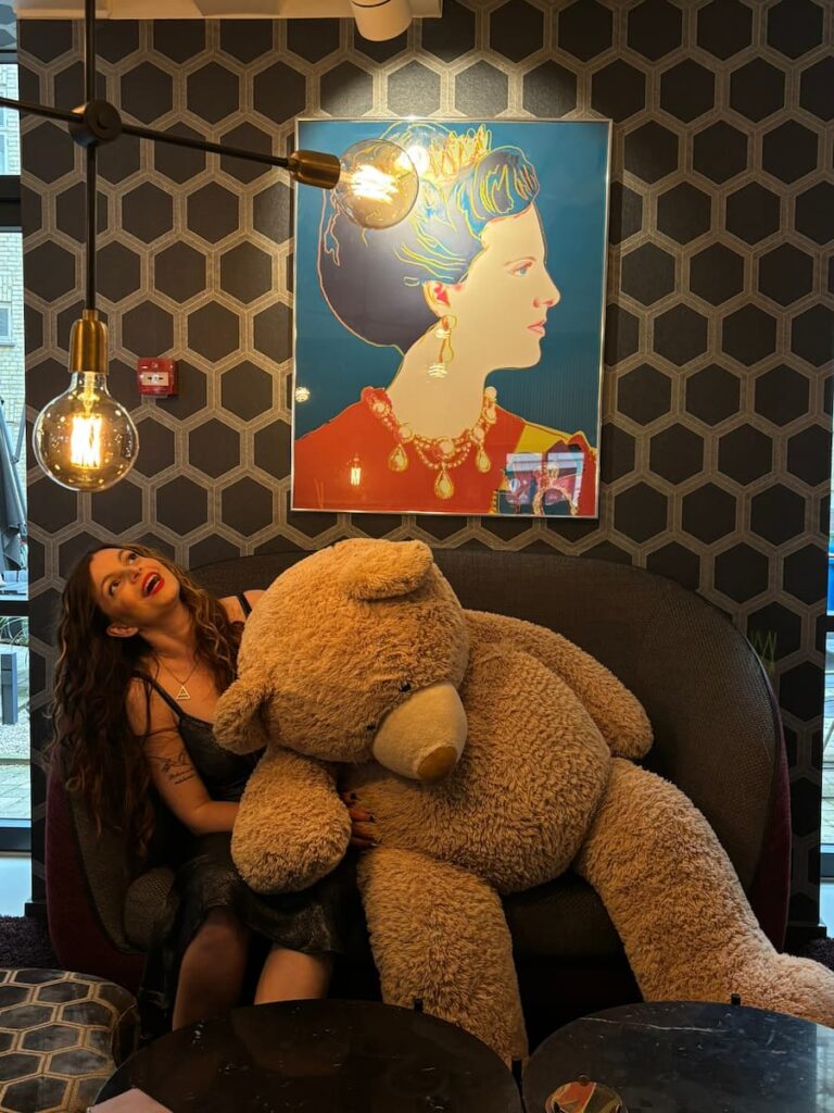 Mirka holding a giant teddy bear at the Andersen Hotel