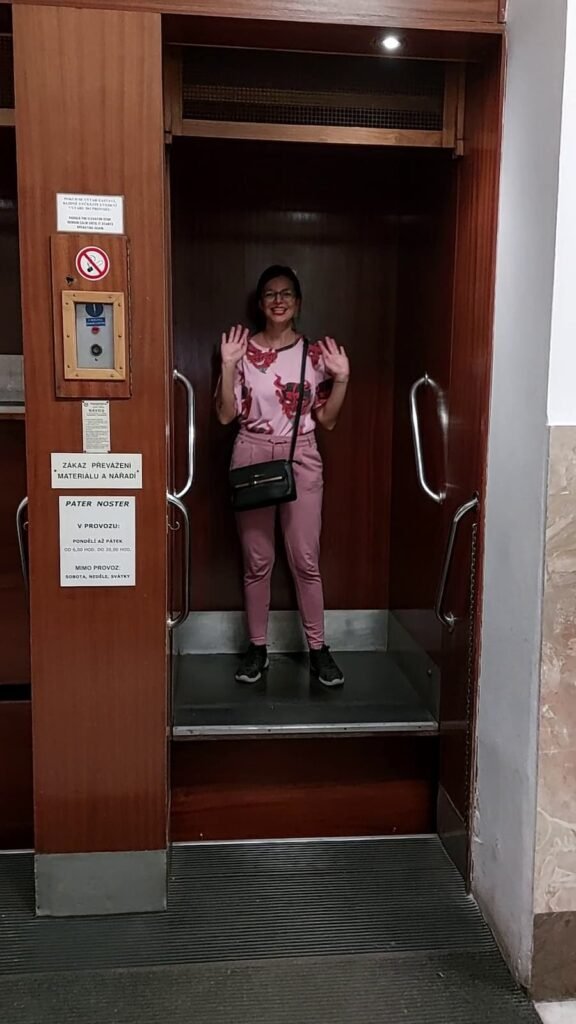 Paternoster Elevator in Prague: All You Need to Know 5 Mirka riding a paternoster elevator in Prague