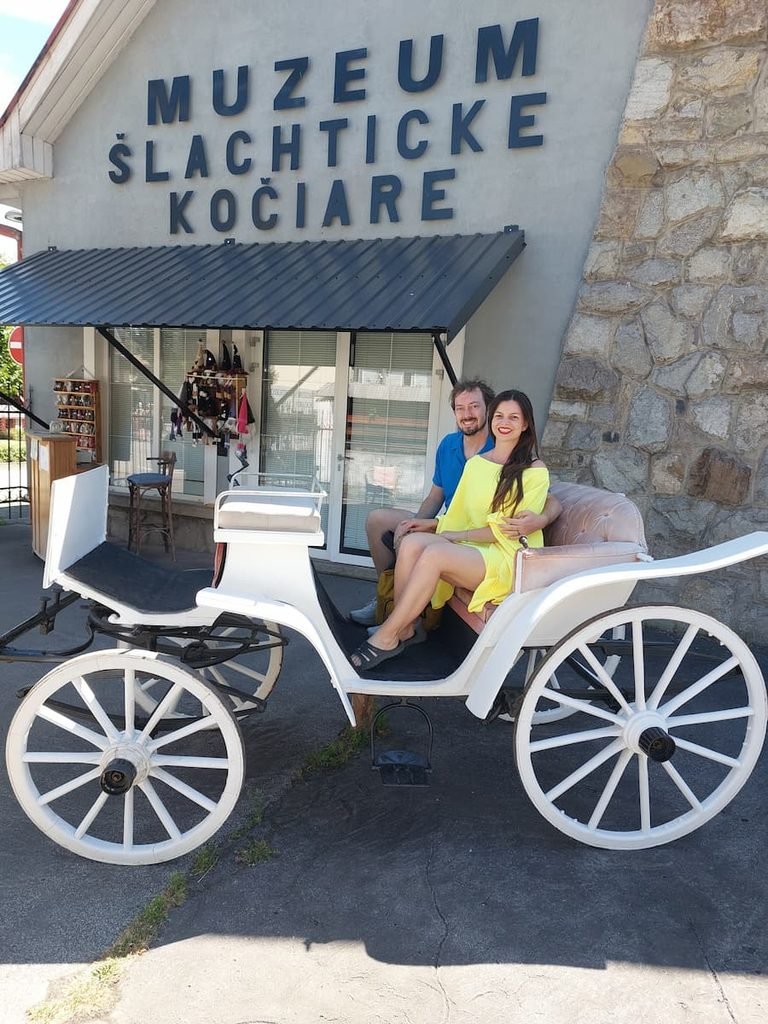 Mirka and Daniel in a carriage outside the Carriage Museum